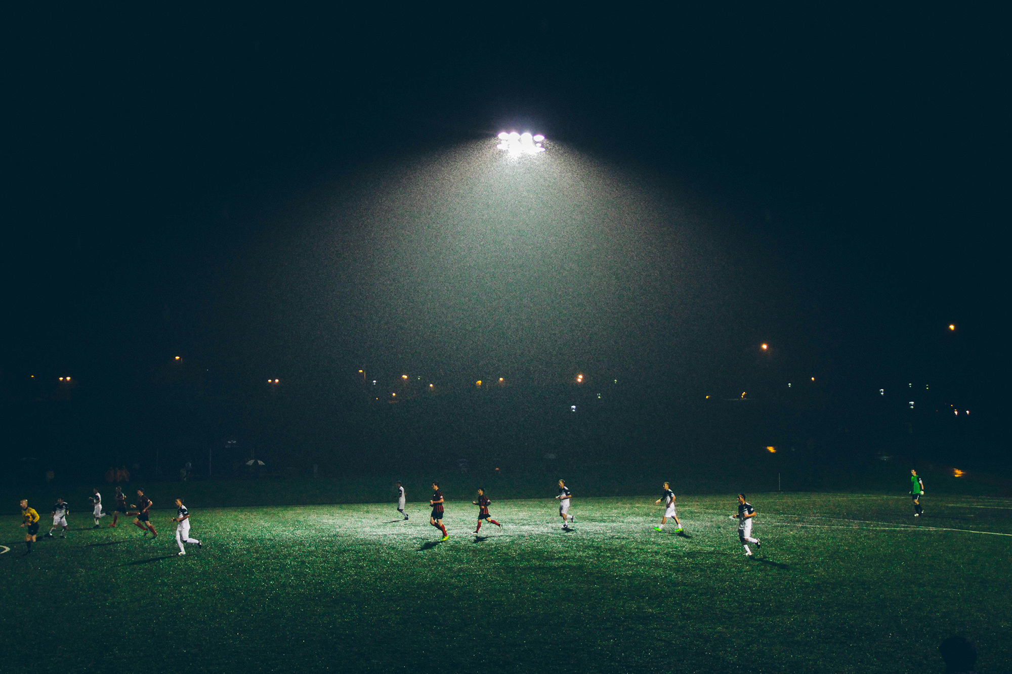 Jugadores de fútbol en cancha nocturna